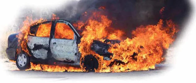 Fotografia d'un turisme totalment envoltat per les flames, amb els vidres trencats, la part davantera i les rodes cremant i una columna de fum fosc.